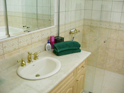 Ba&ntilde;os con sobres de m&aacute;rmol y grifer&iacute;a dorada tradicional